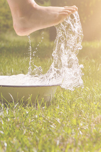 小男孩和飞溅的水在夏天花园里