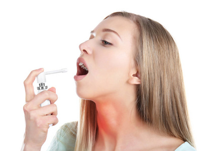 过敏和喉咙痛的概念。生病的年轻女子，在白色背景上使用喷雾