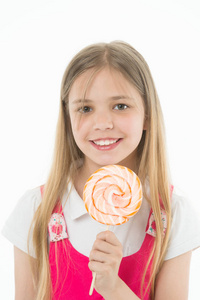 女孩的微笑与糖果隔离在白色。小孩子在棍子上微笑与糖果。快乐的孩子与漩涡焦糖。食物和甜点。享受糖果棒糖。饮食和节食