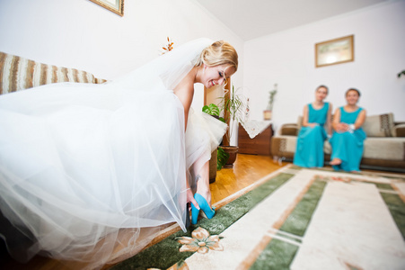 快乐的新娘穿上婚纱的鞋子