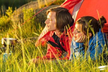 从帐篷里欣赏日落的年轻夫妇