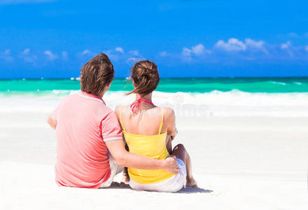 情侣度假坐在蓝色海滩
