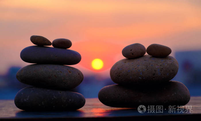 黄色的太阳和卵石石头在剪影, 堆栈的岩石平衡, 使抽象的背景