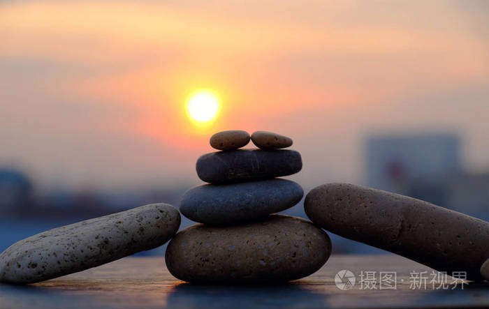 黄色太阳和卵石石头在剪影, 堆岩石平衡做抽象背景