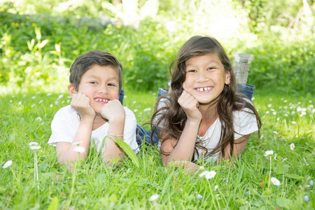 弟弟和妹妹躺在草地上灿烂的笑容和幸福