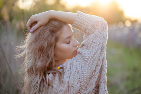 夏天在田野里可爱迷人的女孩。年轻妇女是愉快