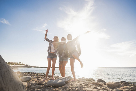 三国集团美丽漂亮的年轻女子跳跃着欢乐与快乐, 独立生活在友谊中。特内里费岛石海滩在阳光明媚的日子里, 享受时光