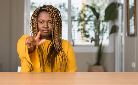 非洲裔美国妇女在家里指着手指到相机和你, 手势, 正面和自信的手势从前面