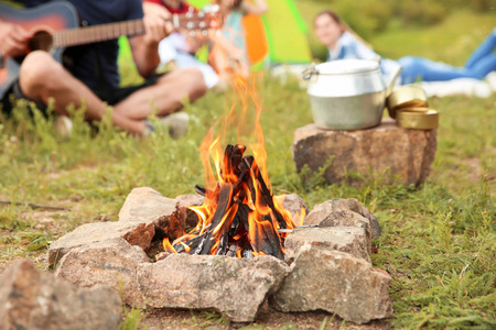 一群人在户外休息, 集中精力在篝火上。野营季节