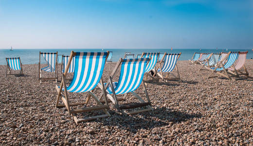 在海滩上的空传统条纹的躺椅