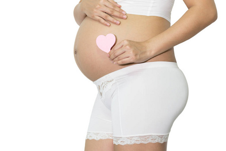 孕妇手捧空白粉红纸注心腹部, 健康概念, 与复制空间隔绝白色背景