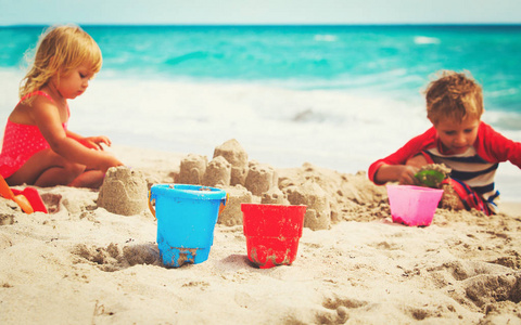 小男孩和女孩建立在海滩的沙堡
