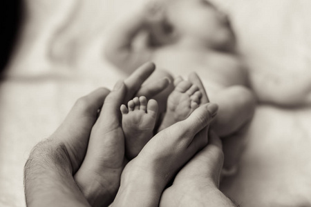母亲抱着新生的婴儿的微小脚