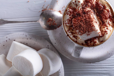 在白色木桌上洒上巧克力片的热巧克力和棉花糖