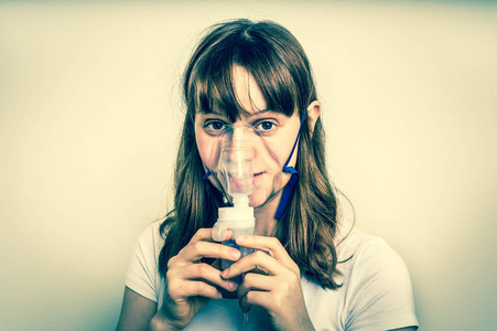 哮喘症状使吸入带面具的女人