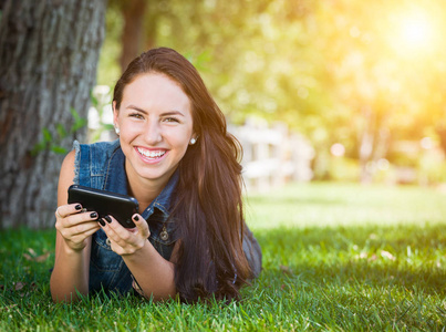混的血年轻女性发短信手机外面在草地上