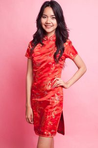可爱的亚洲女孩在中国红色旗袍礼服粉红色背景