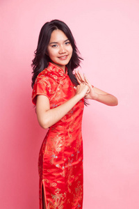 可爱的亚洲女孩在中国红色旗袍礼服粉红色背景
