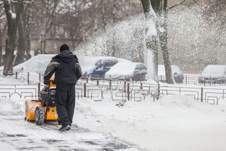基辅，乌克兰2016 年 1 月 9 日 一个人清理积雪从人行道用吹雪机