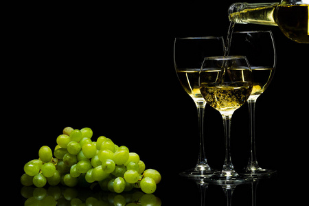 酒和一串葡萄在黑色背景上的眼镜