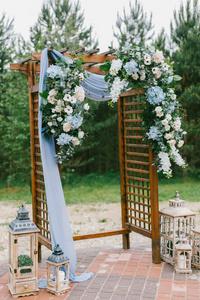 在乡间婚礼上用蓝色布和木制的花拱