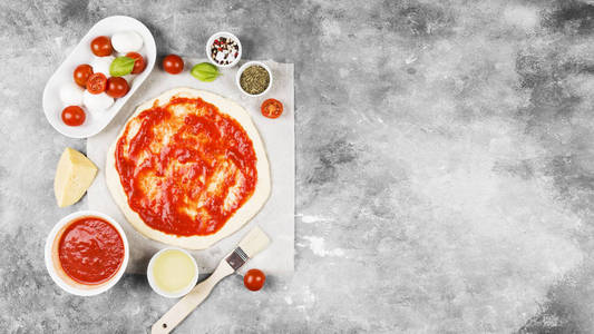 比萨面团和配料的灰色背景比萨饼。顶部视图, 复制空间。食品背景