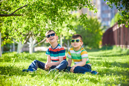 暑假快乐。绿色草坪上的两个快乐的孩子