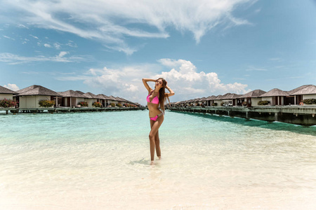 时尚的照片美丽的女孩与深色的头发在优雅的沙滩衣服, 放松在马尔代夫岛海滩