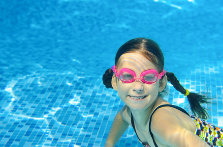 儿童游泳池水下快乐活泼的女孩有护目镜