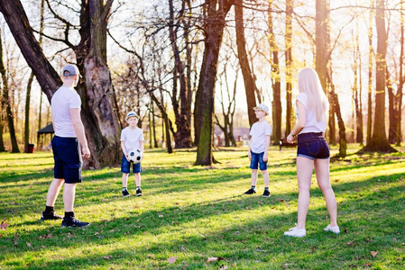 家庭投掷球在绿色草在公园