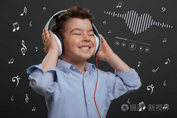 积极的孩子在听音乐的时候闭上眼睛.