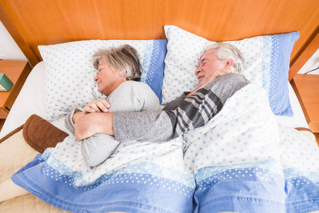 停止闹铃, 不要醒来, 留在床上为家里的年长夫妇休息。室内懒晨概念生活天与窗口光