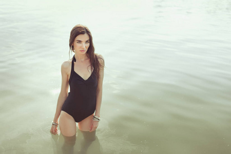 穿着黑色泳衣的漂亮女人站在水里