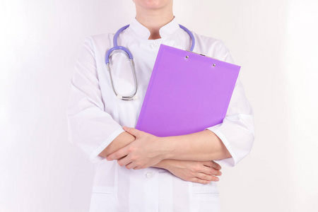 医生在白色长袍与听诊器, 与文件夹在手, 在白色隔绝的背景