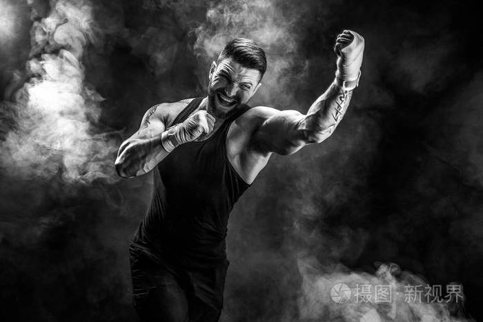 运动员拳泰国拳击手战斗黑色背景与烟雾照片-正版商用