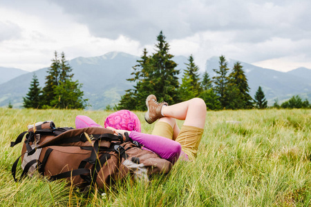 女背包客欣赏绿色夏天山上的景色