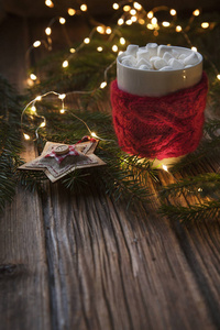 木桌上的圣诞灯, 配有棉花糖和漂亮装饰的杯子特写照片