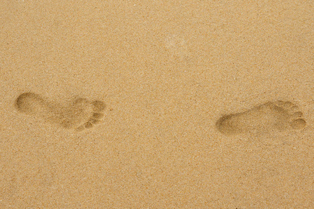 关闭两个脚印在沙子上的视线
