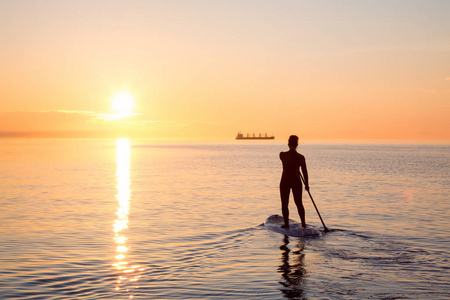 在一个明亮和充满活力的日落, 在桨板上的冒险女孩是 paddeling。靠近西班牙银行, 温哥华, 不列颠哥伦比亚省, 加拿大