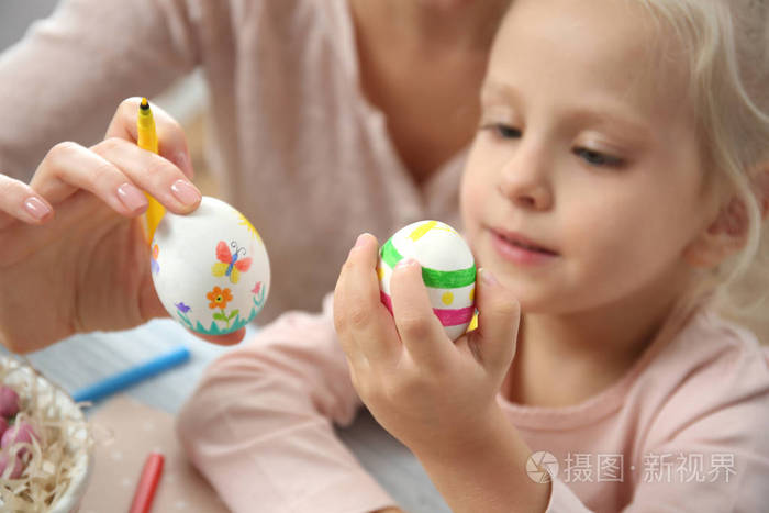 女孩与母亲画鸡蛋复活节