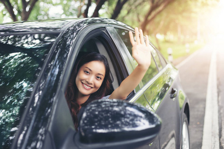 美丽的亚洲女人微笑，enjoying.driving 旅行路上一辆车