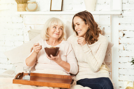 积极的年轻女子与老化祖母在家放松