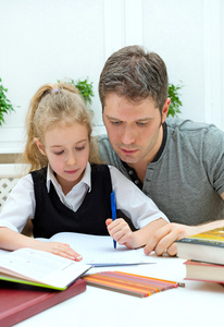 父亲帮女儿在家里做作业