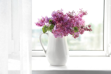壶与美丽的盛开的丁香在窗台上。春天的花朵