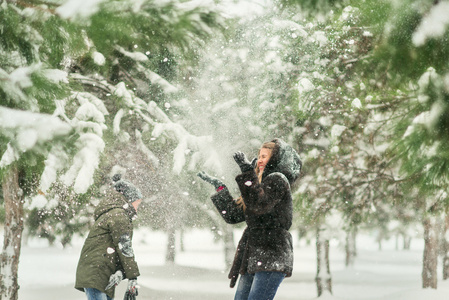 在公园里玩的母亲和儿子在雪地里的冬天