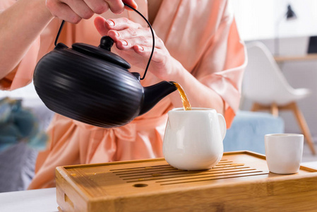 在家里喝茶的时候, 妇女把茶倒入壶里的部分观点