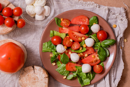 传统的意大利新鲜沙拉 Caprese 由有机樱桃西红柿和迷你干酪 di Bufalla 在野鸡蓝色石头背景。健康和传统食品概念。