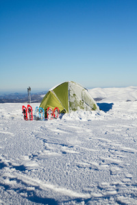 冬山帐篷。帐篷里站在雪地里山。雪是在帐篷旁边