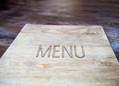 菜单的书刻由木头，在餐厅或咖啡馆的老式装修