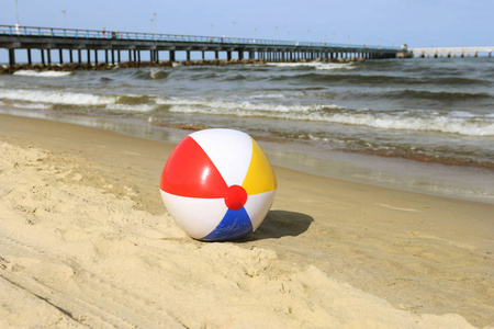 五颜六色的沙滩球在沙滩上挥舞着大海。波罗的海附近的假日沙滩球和地平线上的考纳斯大桥